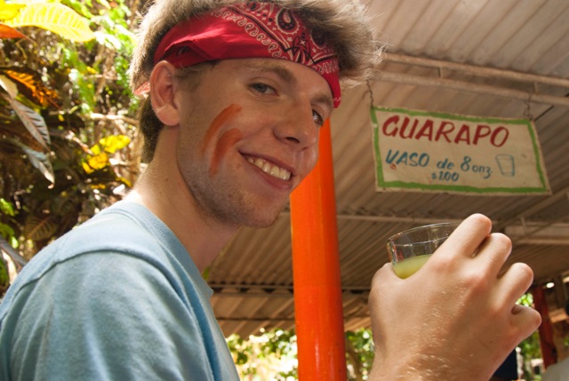Noah tries guarapo, a traditional Cuban drink of fresh pressed sugar cane, at a road side stand. (Photo by Britt Basel)